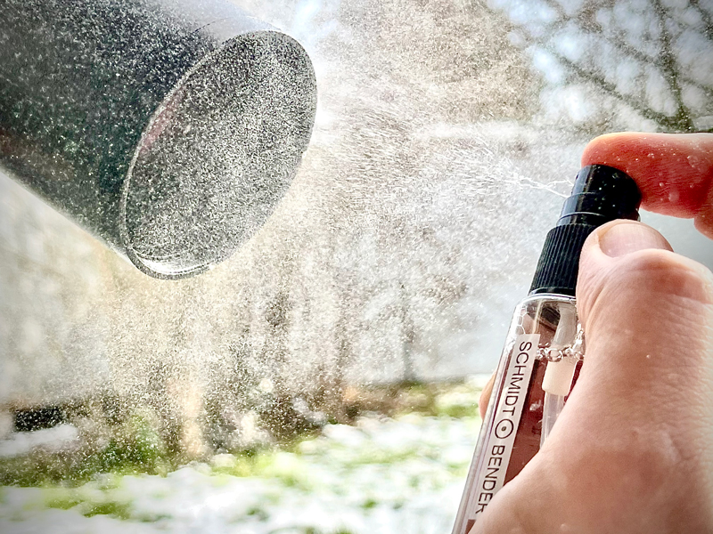 Spruzzare le superfici delle lenti con lo spray di pulizia del Cleaning Kit (2) con un forte getto spray